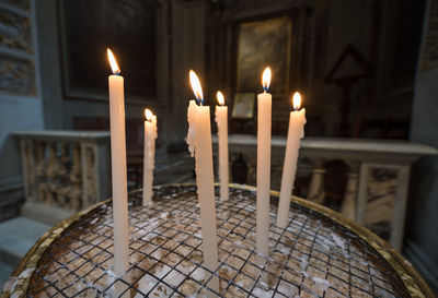 Close-up of illuminated candles in temple