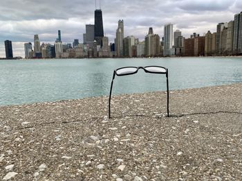 Sea by buildings against sky in city