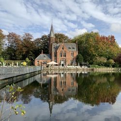 Reflection of building on lake against sky