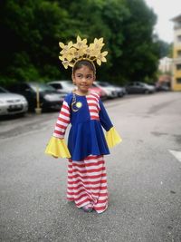 Portrait of a smiling girl standing on road