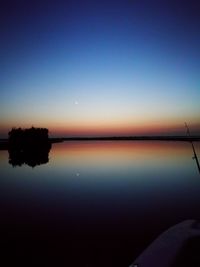 Scenic view of lake against sky at sunset