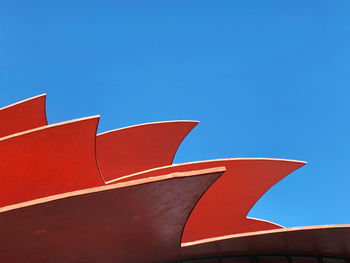 Low angle view of red umbrella against blue sky