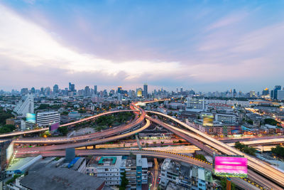 High angle view of illuminated cityscape against sky at sunset