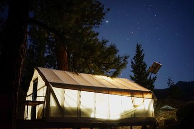 Low angle view of tent on field against clear sky at night