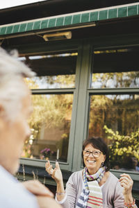 Smiling senior woman gesturing at outdoor cafe