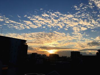 Silhouette cityscape against sky during sunset