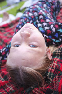 Portrait of girl lying on picnic blanket outdoors