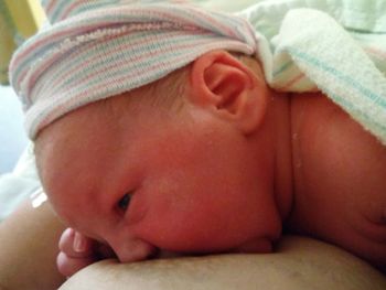 Portrait of cute baby girl lying on bed