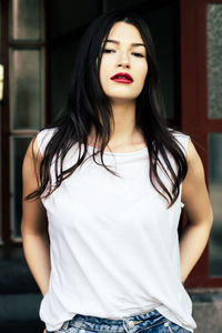 Portrait of beautiful woman posing against windows