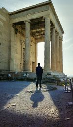 Rear view of man standing at historical building