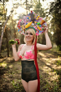 Beautiful young woman standing against tree