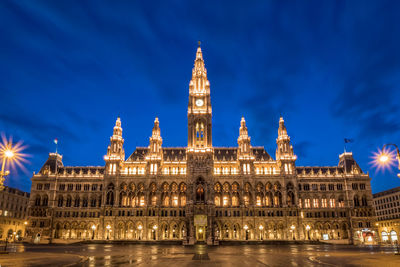 Illuminated building against blue sky at night