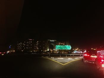 Illuminated cityscape against clear sky at night