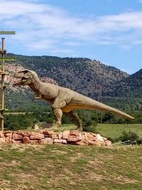 Statue on landscape against sky