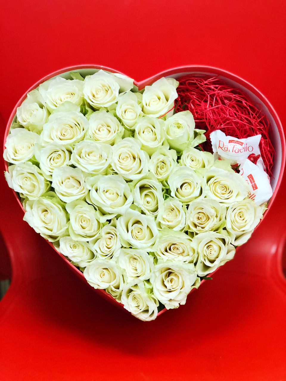 CLOSE-UP OF RED ROSE ON WHITE ROSES