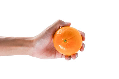 Close-up of hand holding pumpkin against white background