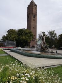 Statue by building against sky