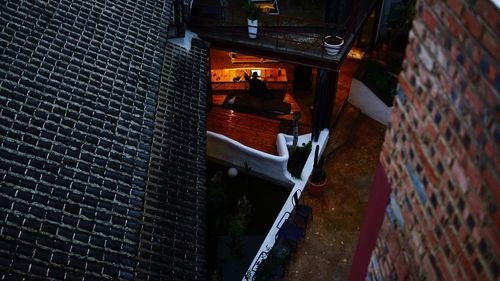 High angle view of silhouette man sitting under illuminated loft at hotel