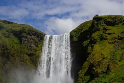 Scenic view of waterfall against sky