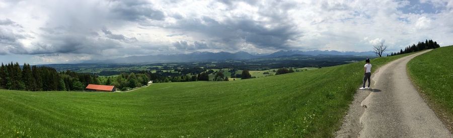 Scenic view of grassy field against cloudy sky