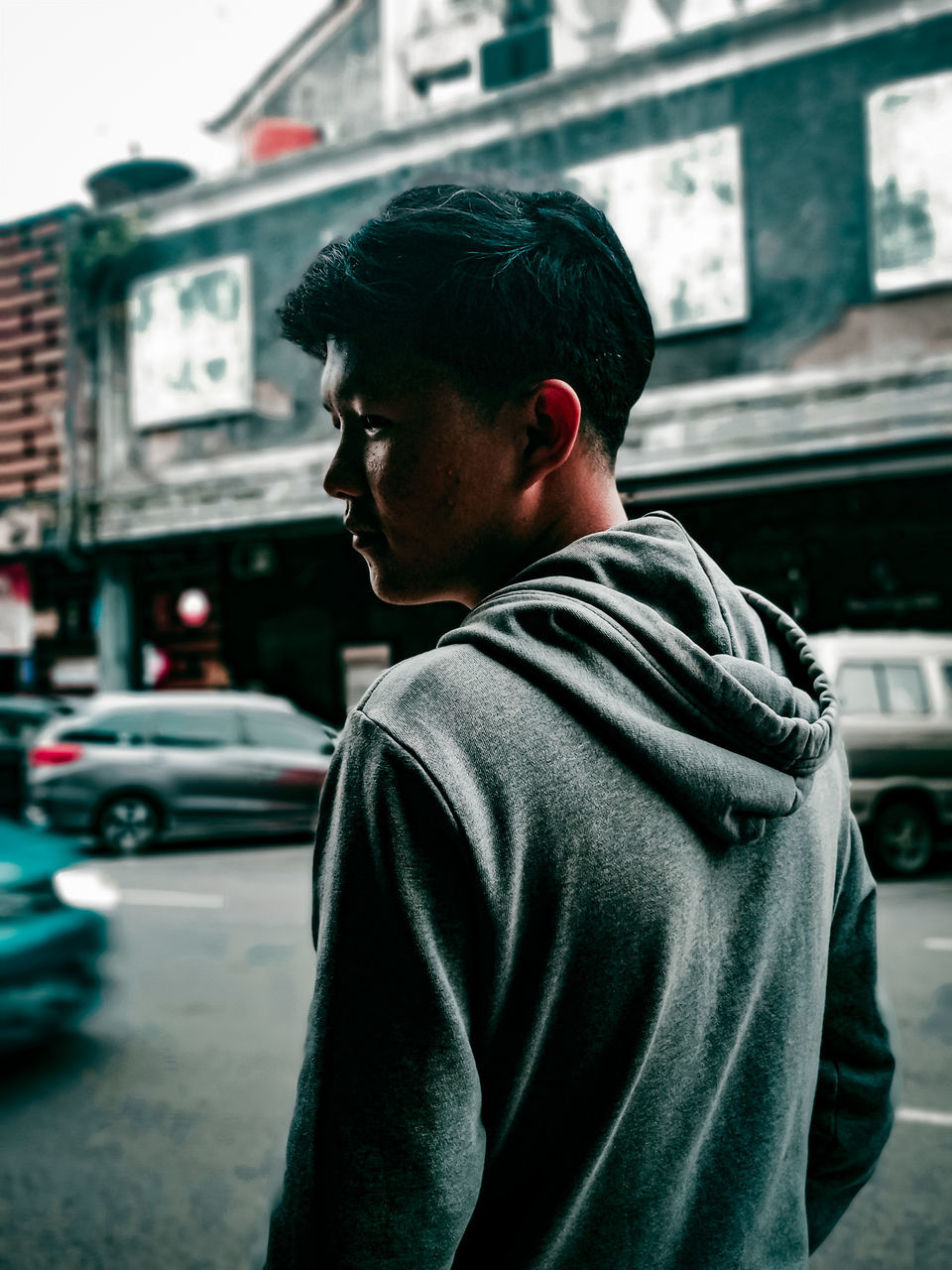 REAR VIEW OF MAN LOOKING THROUGH CAR ON STREET