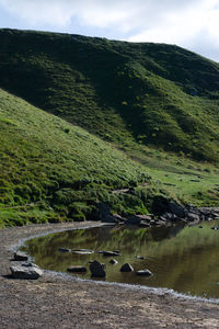 Scenic view of lake by mountain against sky