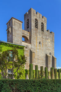 Low angle view of old building against clear blue sky