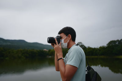 Young man photographer wear mask shooting the camera , travel , freedom and recreation concept