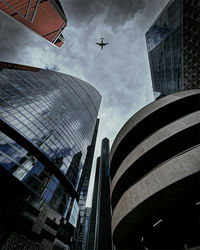 Directly below shot of airplane flyiing over building in city