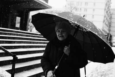 Full length of woman with umbrella standing in rain