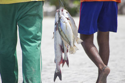 Low section of man fishing in sea