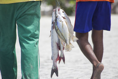 Low section of man fishing in sea