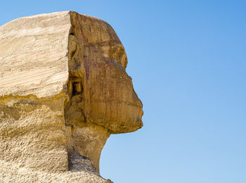 Low angle view of rock formation against clear blue sky