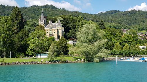 Scenic view of lake by buildings against sky