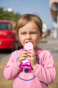 Cute girl eating ice cream on sunny day