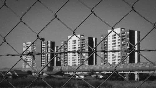 Full frame shot of chainlink fence against buildings in city