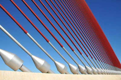 Low angle view of suspension bridge against clear blue sky