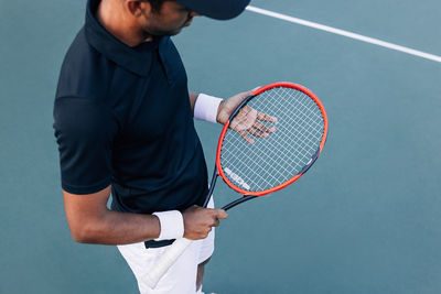 Midsection of man playing tennis