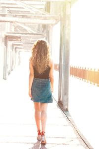 Rear view of woman walking in corridor