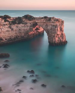 Rock formation in sea against sky