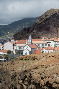 Houses on mountain against sky