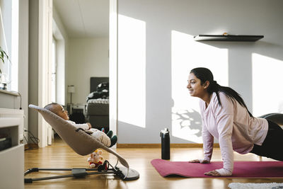 Mother with baby exercising in living room