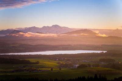 Panoramic view at lake wallersee with snow covered mountain range in background at sunset,, austria