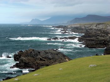 Scenic view of sea and mountains against sky