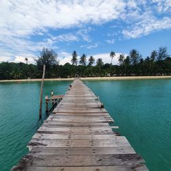 Wooden pier over lake against sky