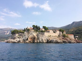 Scenic view of sea by buildings against sky