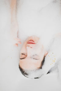 Close-up of young woman with eyes closed in bathroom