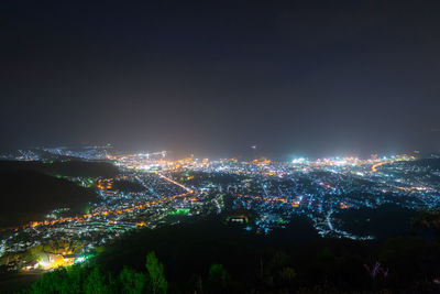 High angle view of illuminated buildings against sky at night