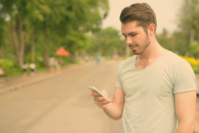 Young man using mobile phone outdoors