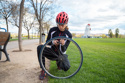 Full length of athlete repairing tire